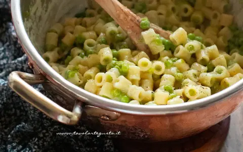 Un primo piatto cremoso di pasta e piselli, pronto per essere gustato.