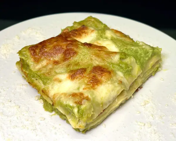 Lasagne con asparagi e speck, un piatto invitante con strati dorati e un ripieno verde brillante.