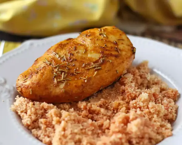 Petto di pollo in friggitrice ad aria, dorato e aromatico, servito su un letto di couscous.