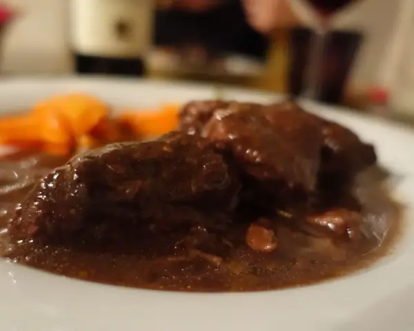 Un succulento brasato al barolo, tenero e saporito, accompagnato da carote arancioni.