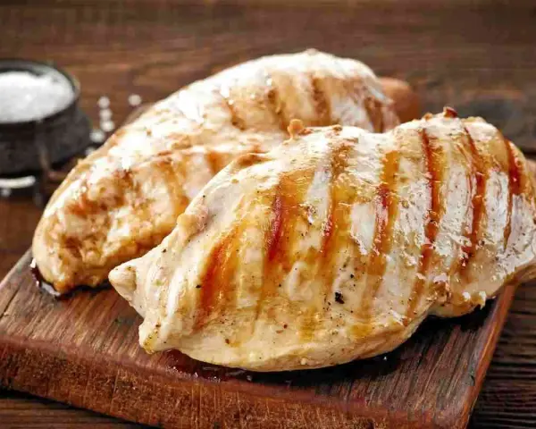 Petto di pollo alla griglia, perfetti secondi di carne da preparare in anticipo. Un contorno di sale completa l'immagine.