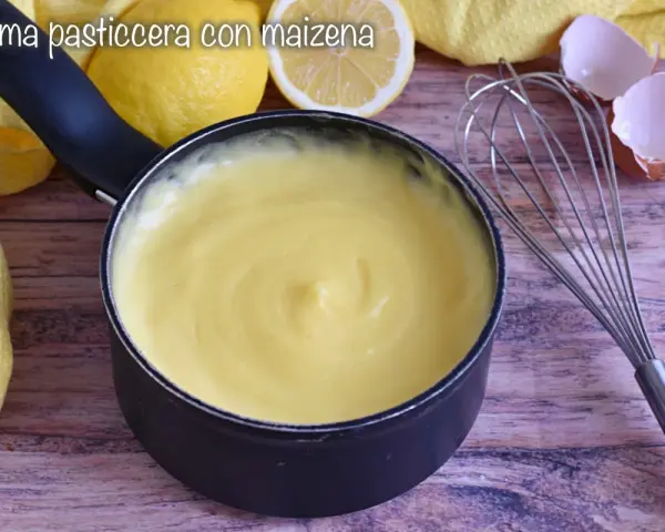 Crema pasticcera con amido di mais, liscia e vellutata, pronta per farcire dolci. Accanto, limoni, frusta e gusci d'uovo.