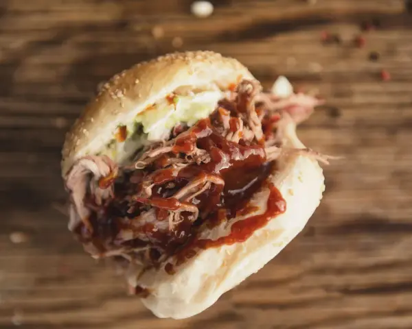 Un panino succulento con pulled pork, salsa barbecue e insalata di cavolo, perfetto per chi cerca una ricetta facile e gustosa.
