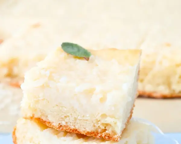 Una fetta di torta di riso carrarina, soffice e profumata, guarnita con una fogliolina verde.
