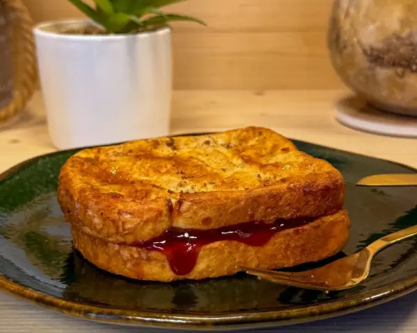 Toast in friggitrice ad aria, dorato e ripieno di marmellata, pronto per essere gustato.