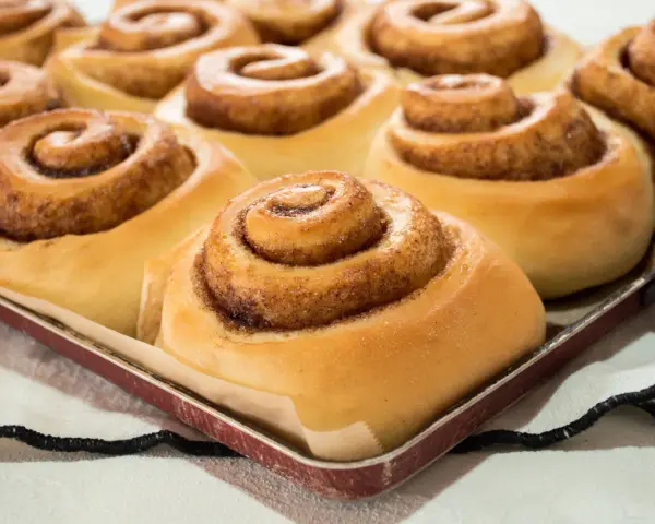 Dolci cinnamon rolls appena sfornati, pronti per essere gustati. Una ricetta perfetta per la colazione o la merenda.