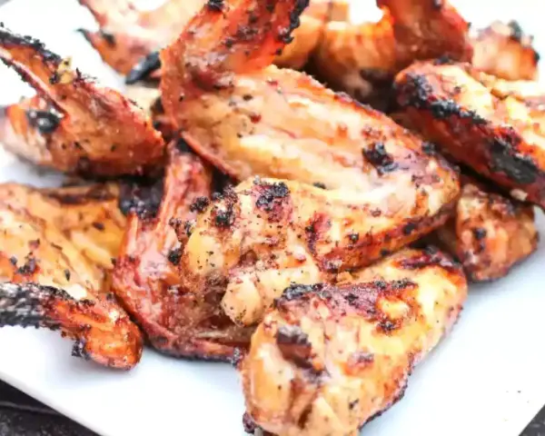 Alette di pollo grigliate, dorate e succulente, pronte per essere gustate.