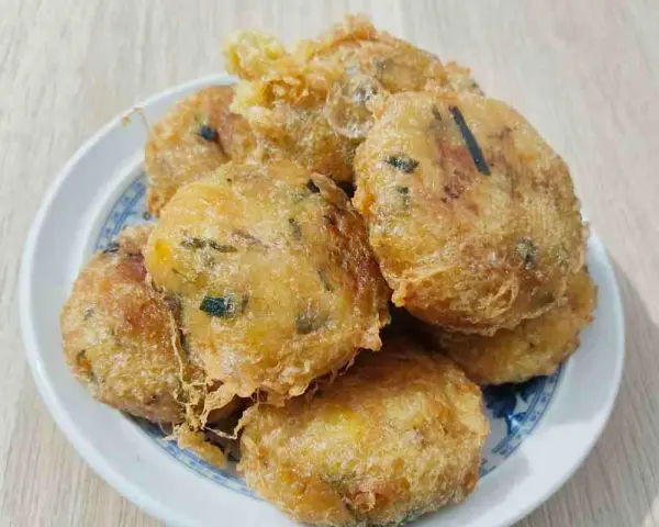 Un piatto di frittelle di zucchine dorate e croccanti, perfette per uno spuntino gustoso.