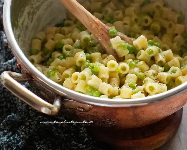 Un primo piatto cremoso di pasta e piselli, pronto per essere gustato.