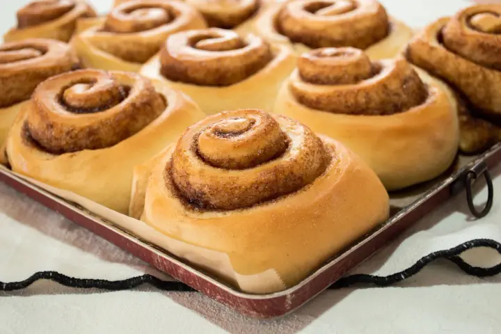 Dolci cinnamon rolls appena sfornati, pronti per essere gustati. Una ricetta perfetta per la colazione o la merenda.