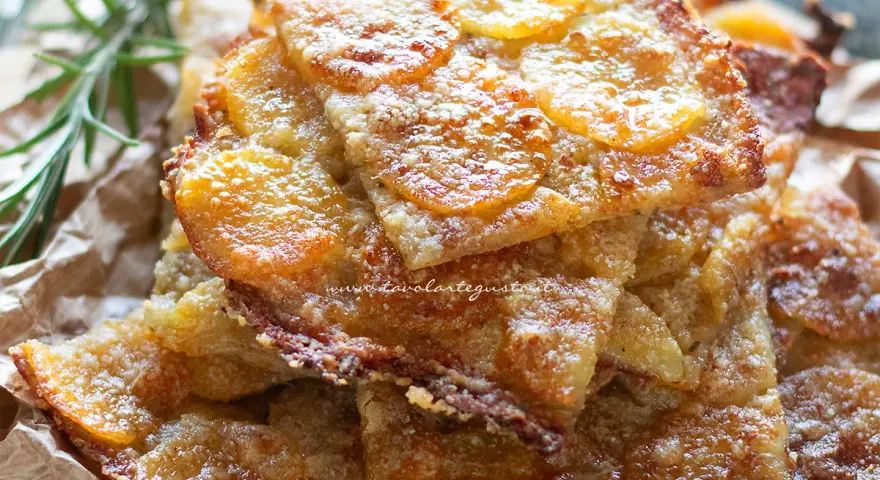 Schiacciata di patate dorata e croccante, con fette sottili di patate e rosmarino.