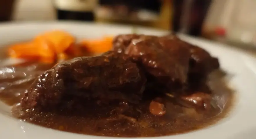 Un succulento brasato al barolo, tenero e saporito, accompagnato da carote arancioni.