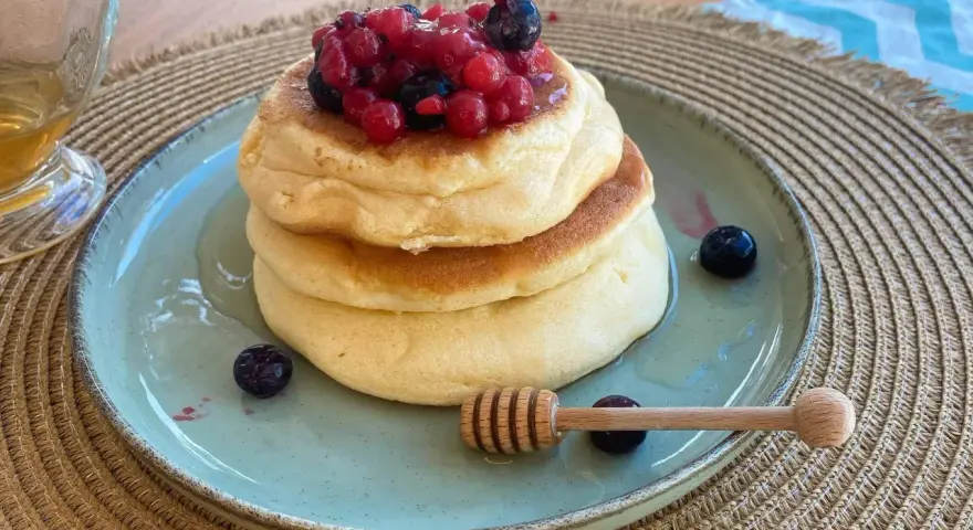 Pancake con albumi soffici, guarniti con frutti di bosco e miele. Un dolce leggero e goloso.