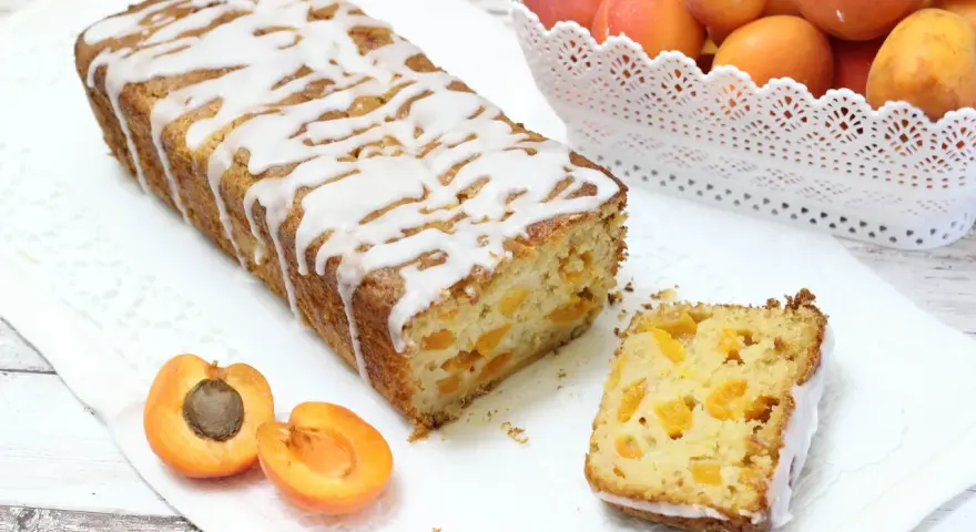 Plumcake senza uova con albicocche fresche, glassato con una leggera copertura bianca. Un dolce soffice e profumato, perfetto per la colazione o la merenda.