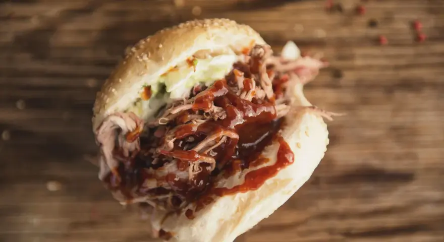Un panino succulento con pulled pork, salsa barbecue e insalata di cavolo, perfetto per chi cerca una ricetta facile e gustosa.