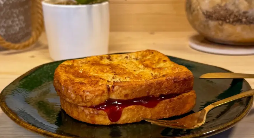 Toast in friggitrice ad aria, dorato e ripieno di marmellata, pronto per essere gustato.