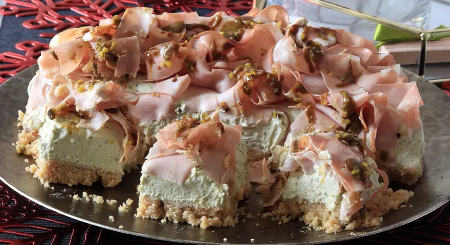 Cheesecake salata con taralli, mortadella e pistacchi. Una torta scenografica e gustosa, perfetta per un aperitivo o un antipasto originale.