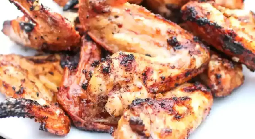 Alette di pollo grigliate, dorate e succulente, pronte per essere gustate.