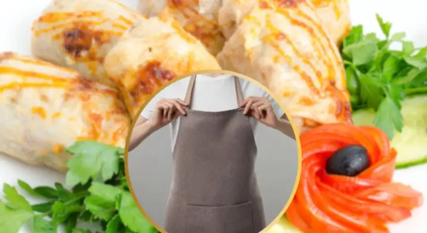 Involtini di pollo succulenti, guarniti con pomodoro a forma di fiore, cetrioli e prezzemolo fresco. Una persona indossa un grembiule, pronta a servire.