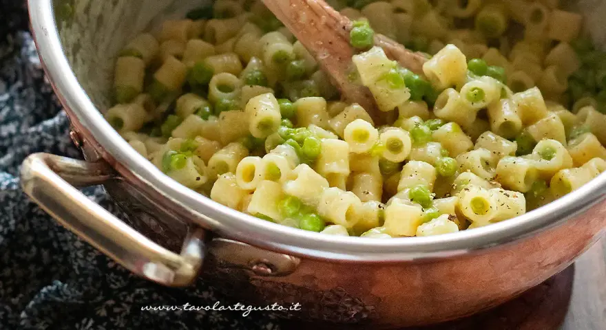 Un primo piatto cremoso di pasta e piselli, pronto per essere gustato.