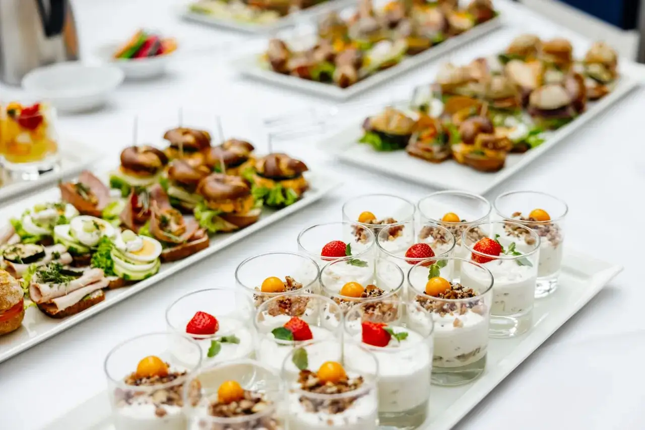 Variet&agrave; di antipasti velocissimi senza cottura: mini hamburger, tartine con uova e salumi, e dolci al bicchiere con frutta fresca e granella.