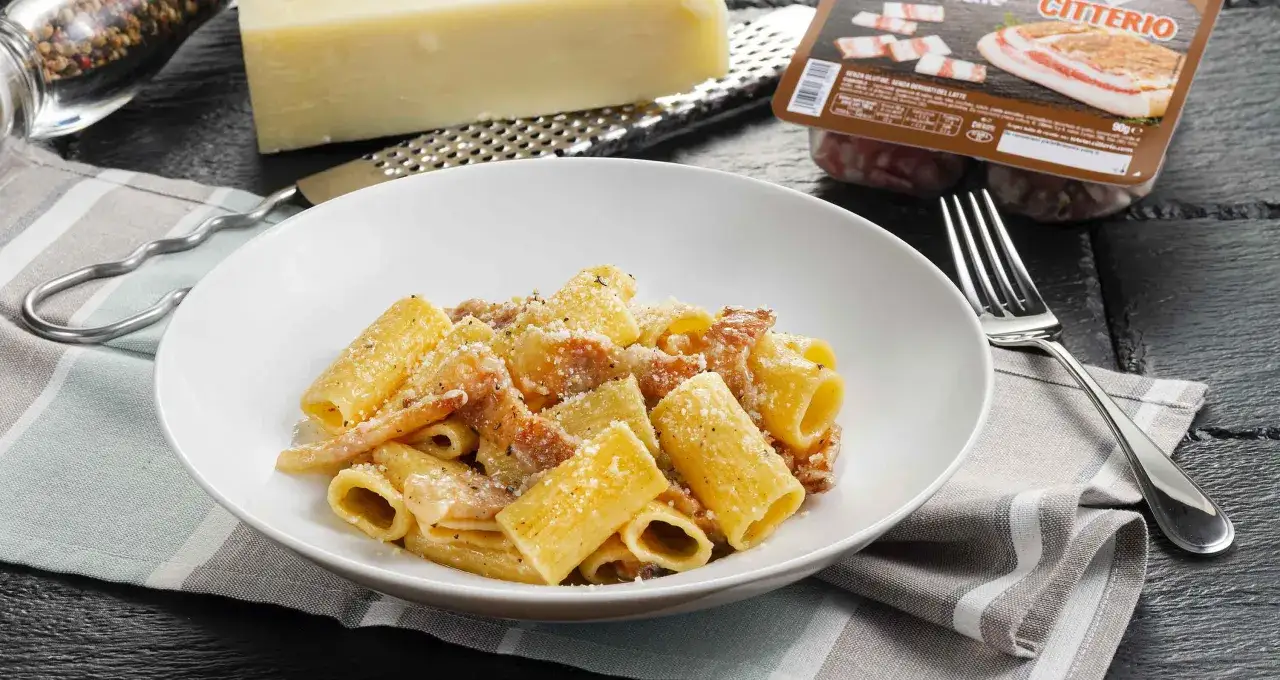 Un piatto fumante di pasta alla gricia, condita con guanciale croccante e pecorino romano. Ingredienti freschi e un sapore autentico.