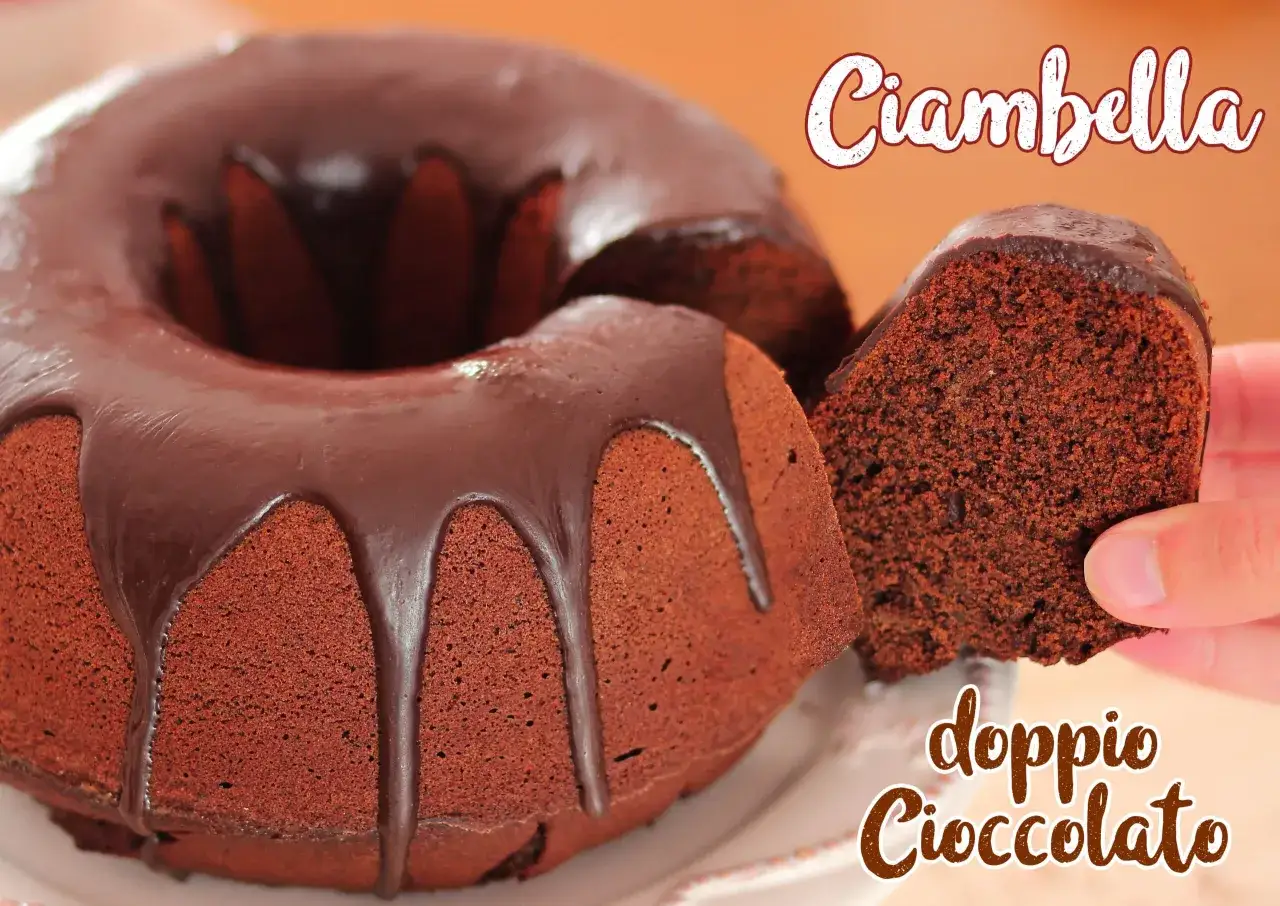 Ciambellone al cioccolato con glassa fondente. Una fetta viene sollevata, mostrando la morbida consistenza interna.