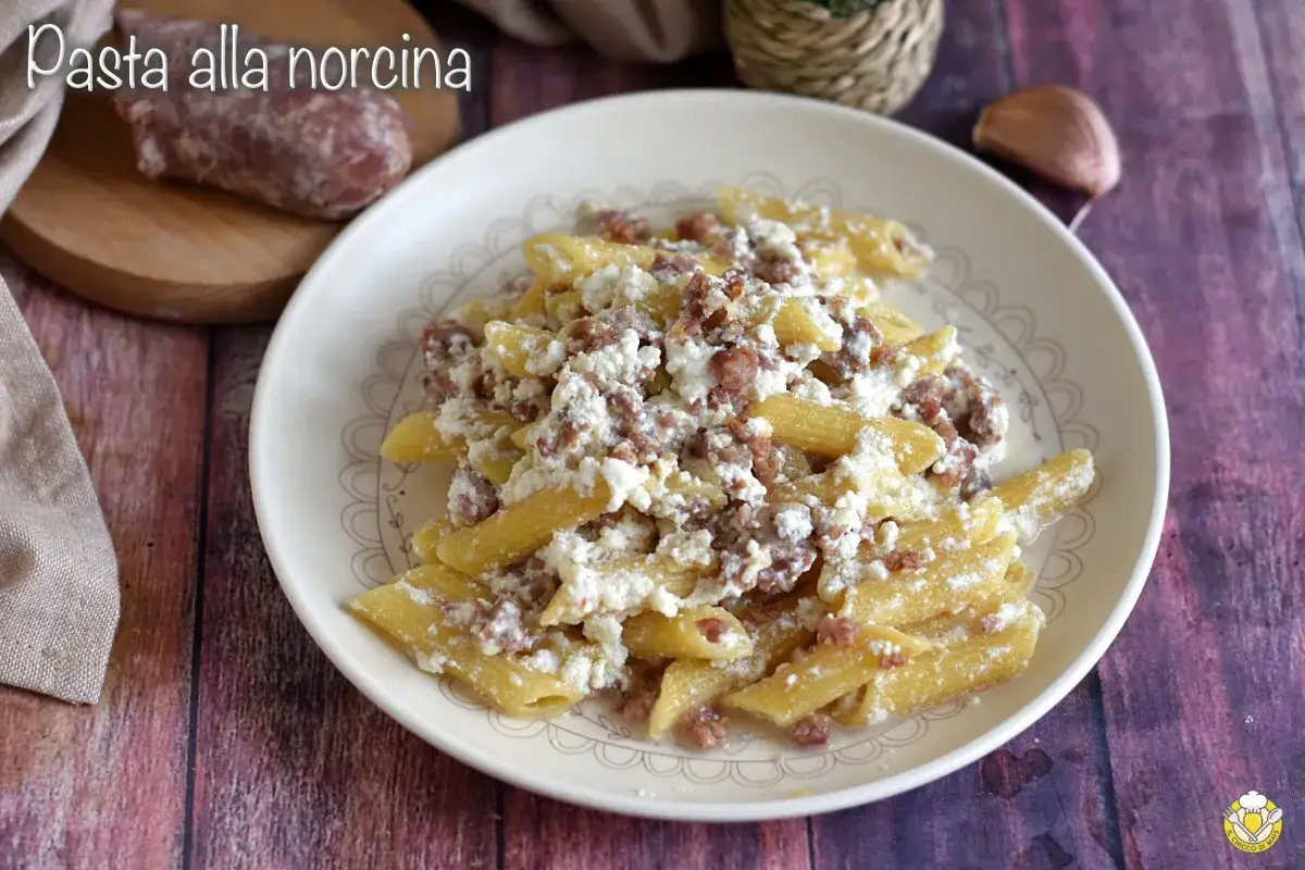 Piatto di pasta alla norcina con salsiccia sbriciolata e ricotta cremosa, un classico della cucina umbra.