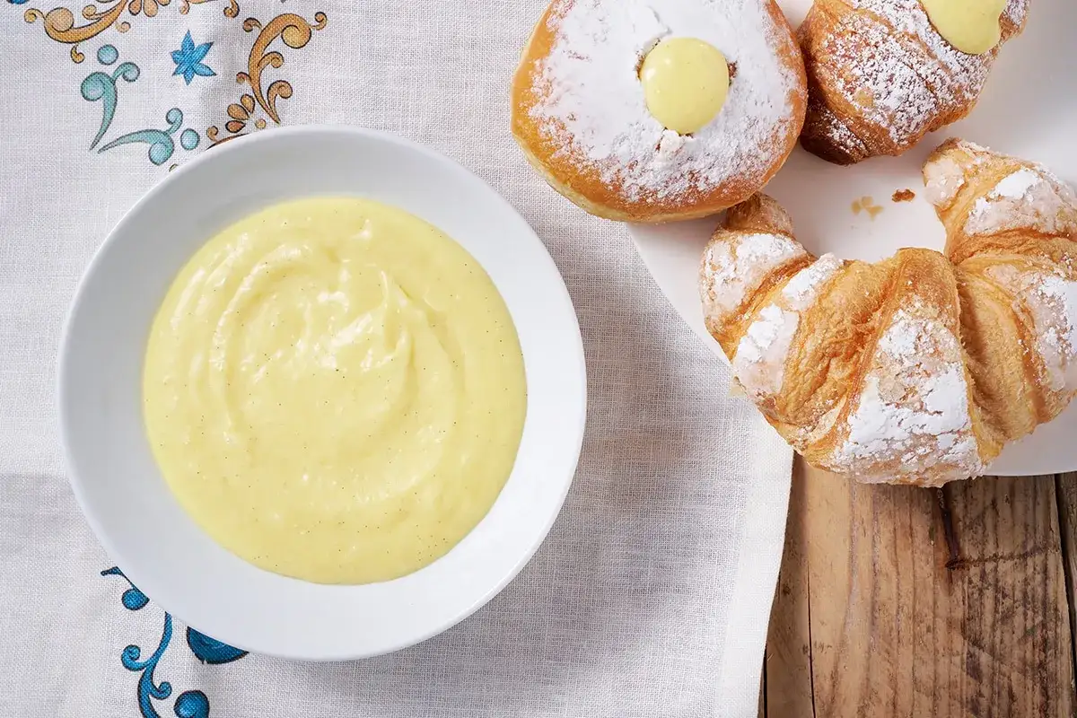 Una ciotola di deliziosa crema pasticcera senza uova, perfetta per farcire cornetti e bomboloni.
