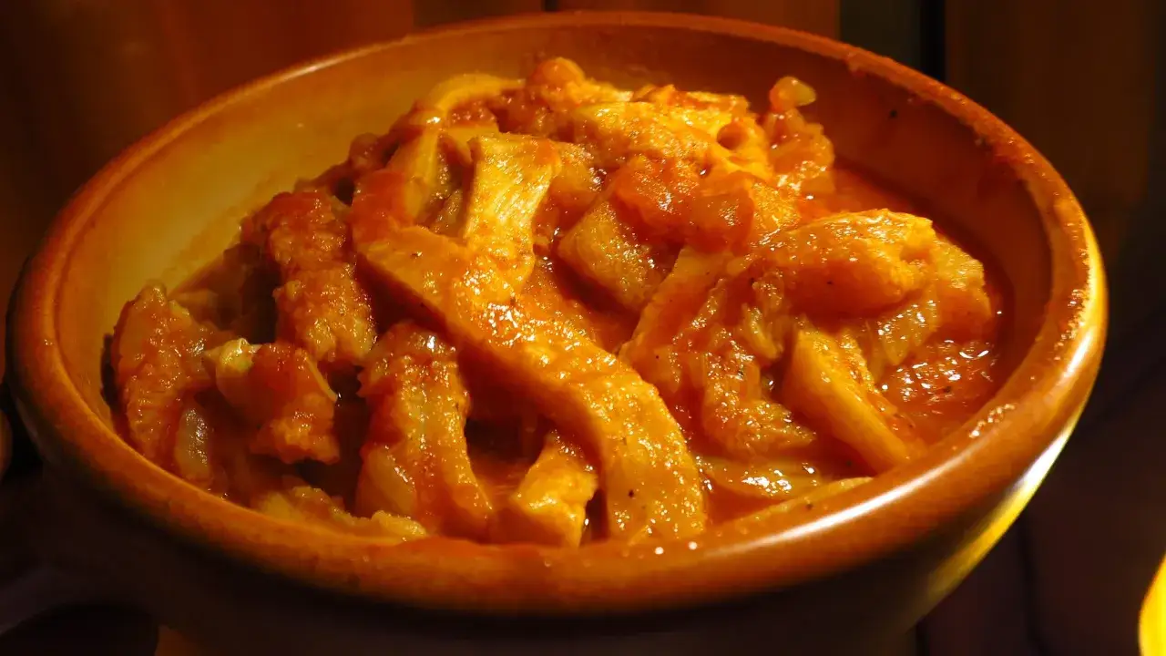 Un invitante piatto di trippa alla parmigiana in una ciotola di terracotta, pronto per essere gustato.