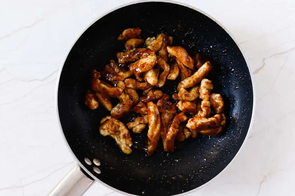 Straccetti di pollo succulenti e dorati in padella, pronti per essere gustati.
