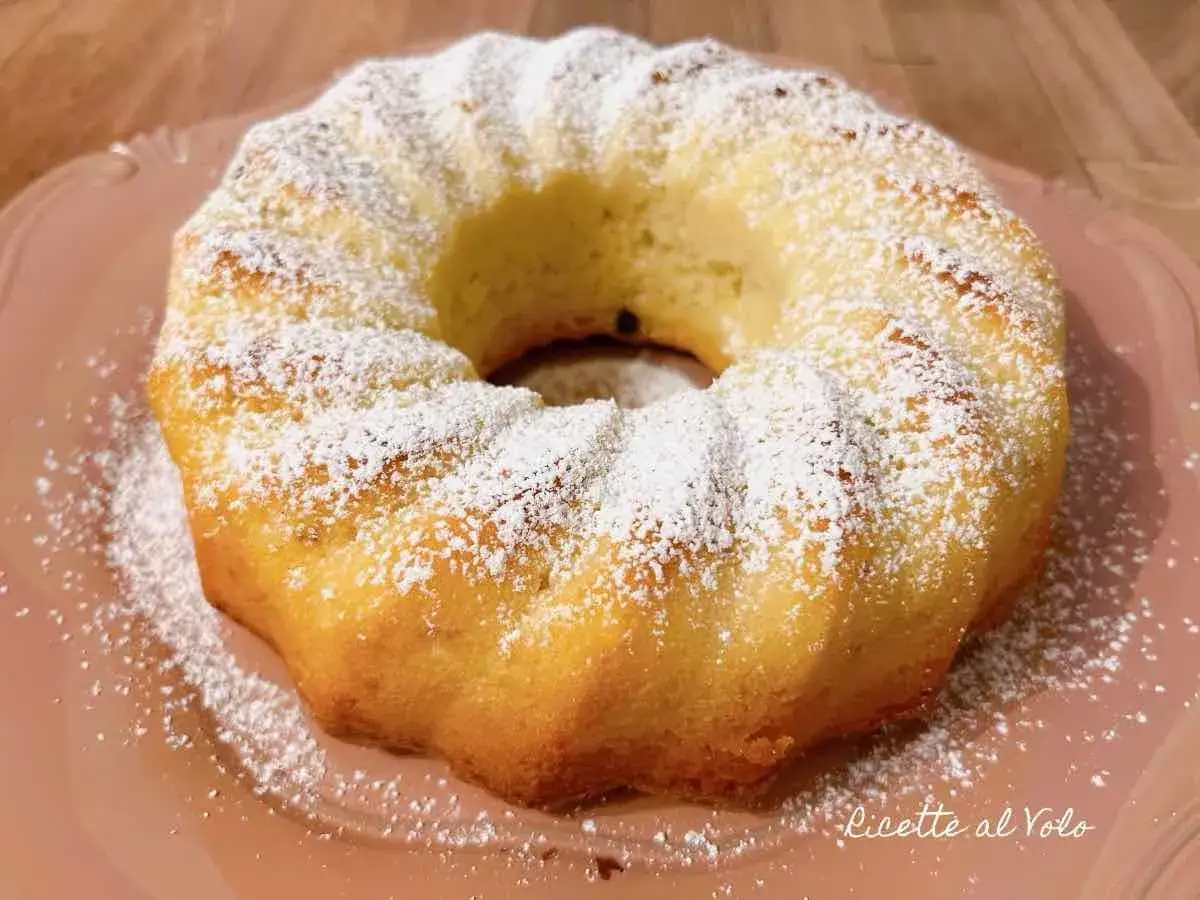 Un soffice ciambellone allo yogurt, cosparso di zucchero a velo, pronto per essere gustato.