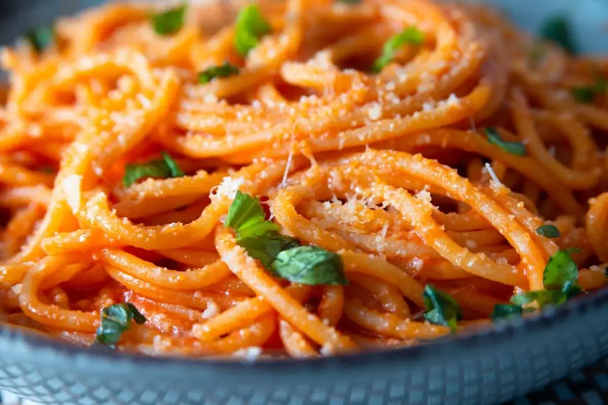 Spaghetti conditi con un cremoso sugo al pomodoro e basilico fresco, spolverati di parmigiano. Un classico dei sughi per pasta.