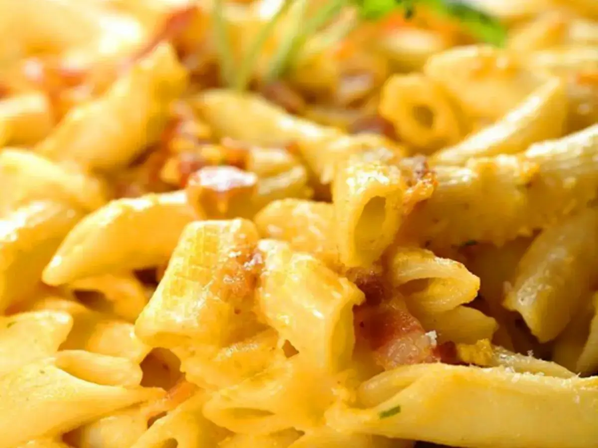 Penne cremose con pancetta croccante, un delizioso mac and cheese che invita a un morso.