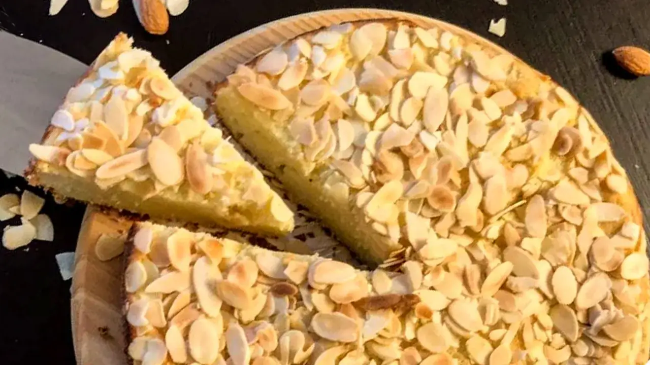Torta con farina di mandorle, ricoperta di mandorle a lamelle tostate. Una fetta &egrave; gi&agrave; stata tagliata.