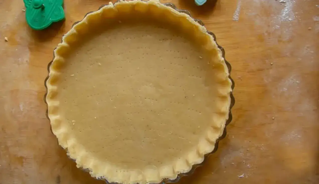 Base per crostata pronta, una deliziosa pasta frolla senza burro, con bordi decorati e forata per una cottura perfetta.