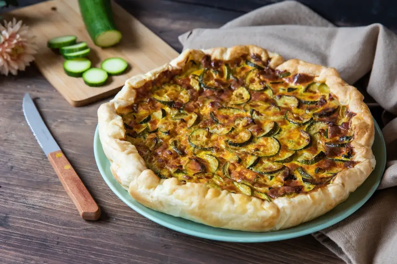 Tortino di zucchine dorato e invitante, con fette di zucchine fresche e un bordo croccante. Perfetto per un pranzo leggero.