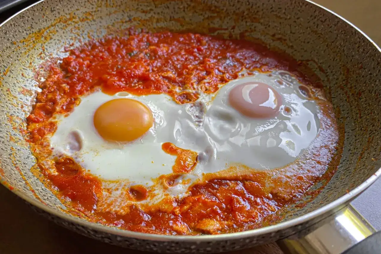 Uova in purgatorio, due uova cotte in una salsa rossa piccante, in una padella.