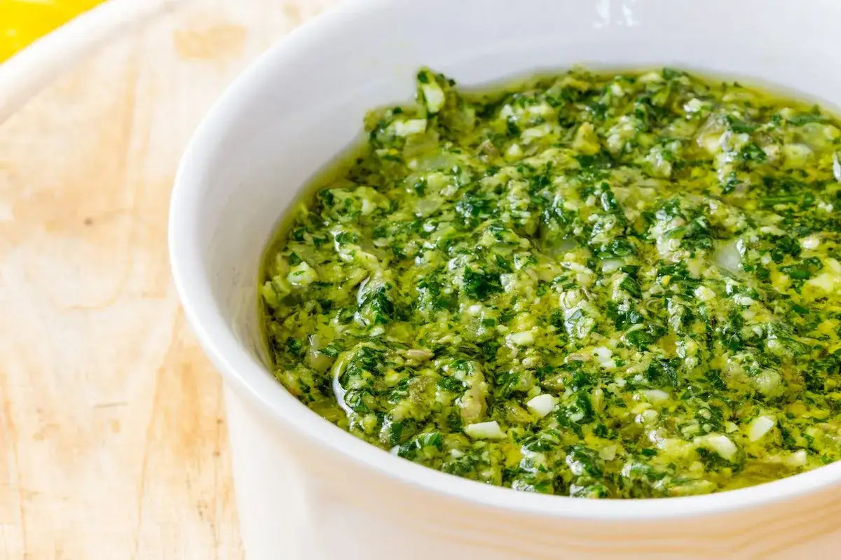 Salsa verde senza uovo, un condimento fresco e aromatico a base di erbe, aglio e olio, pronto per insaporire i tuoi piatti.