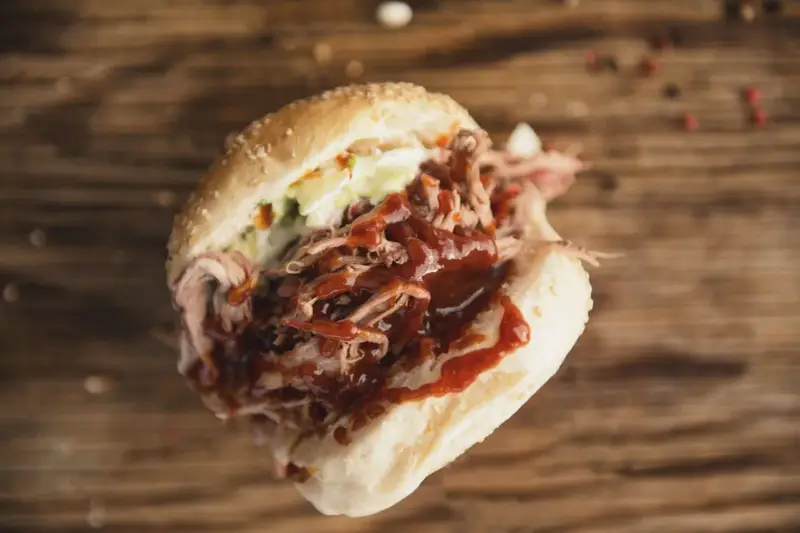 Un panino succulento con pulled pork, salsa barbecue e insalata di cavolo, perfetto per chi cerca una ricetta facile e gustosa.